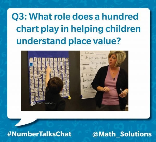 student pointing at the number 15 in a grid of numbers. a teacher stands nearby | q3: what role does a hundred chart play in helping children understand place value? #numbertalkschat @math_solutions