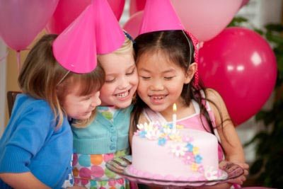 Children at a birthday party with a cake.