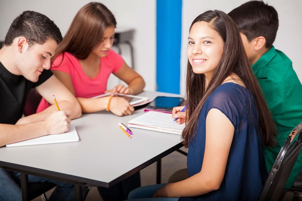 Group of Latin high school students working together in a classroom