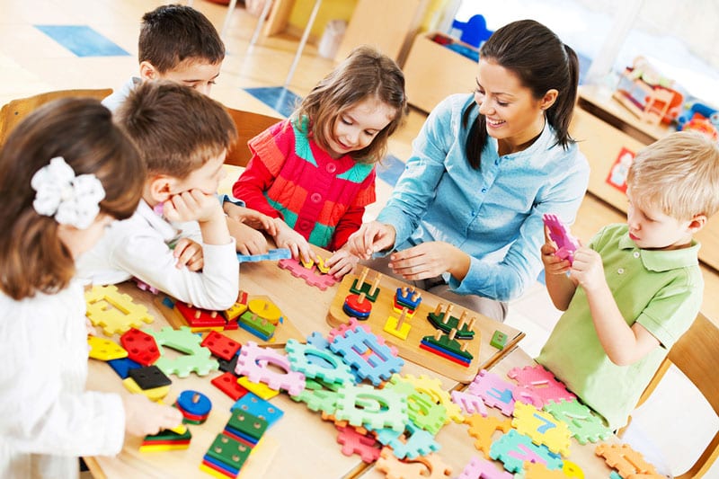 teacher and students counting with number blocks