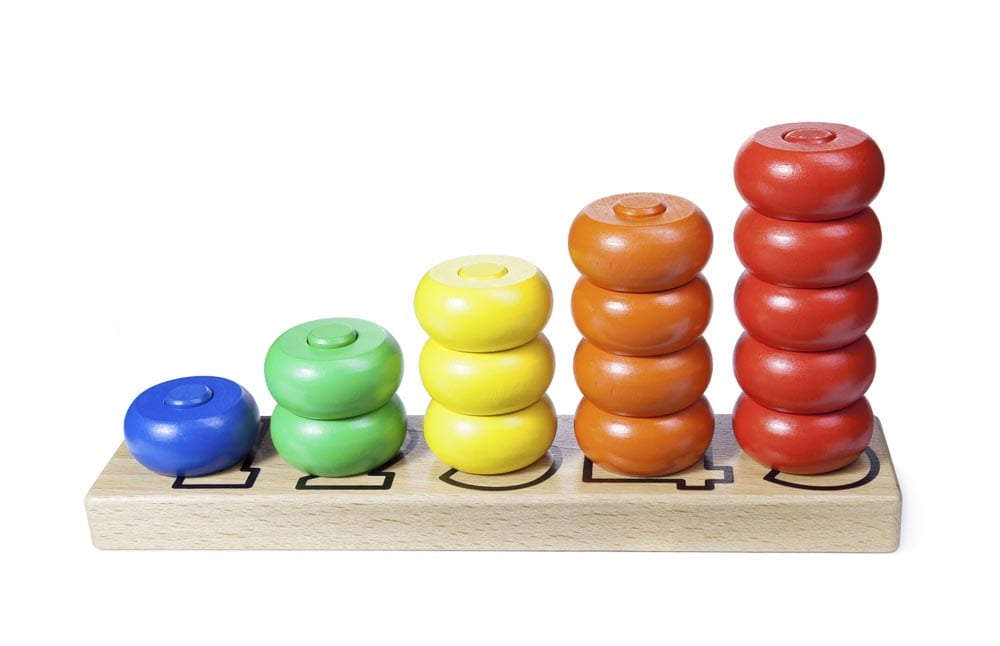 Wooden children toy scores from one to five of the colored rings on a white with clipping path