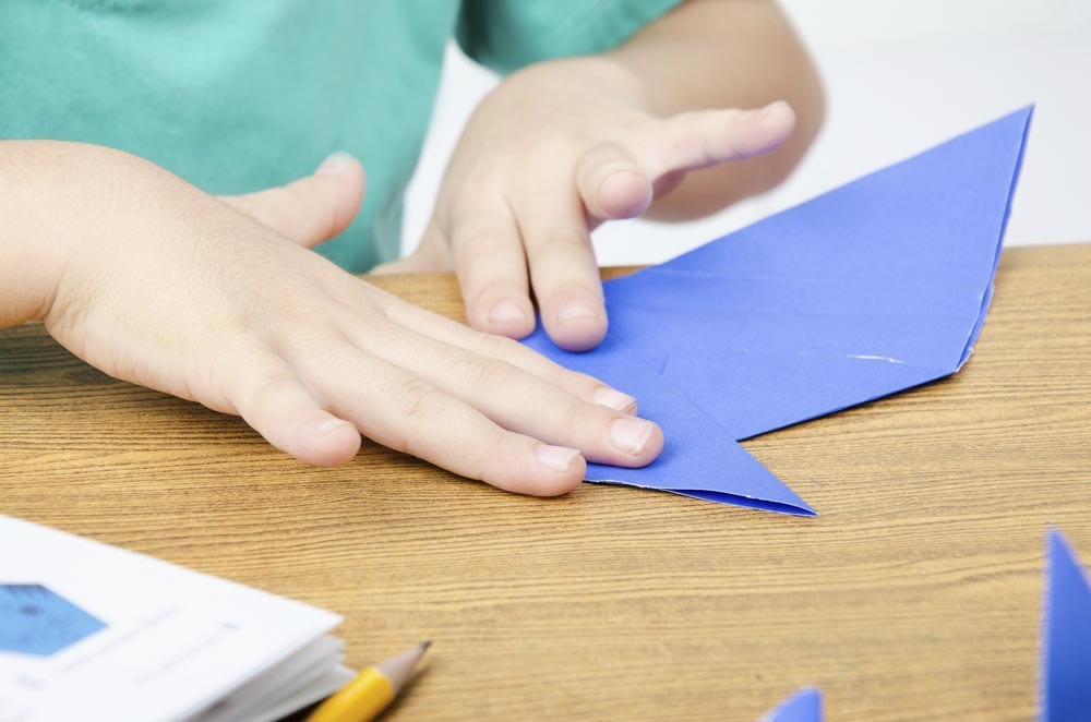 Little boy folding paper art origami