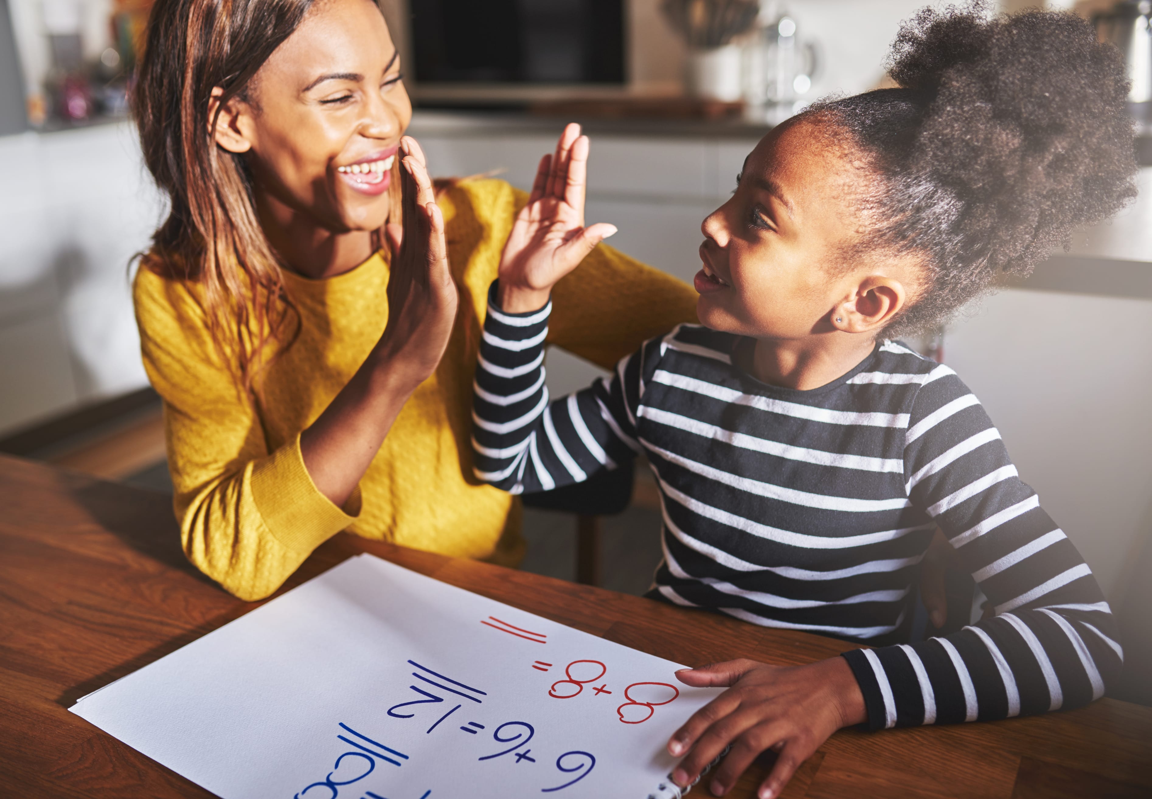 Mother and young child learning to calculate, high five success